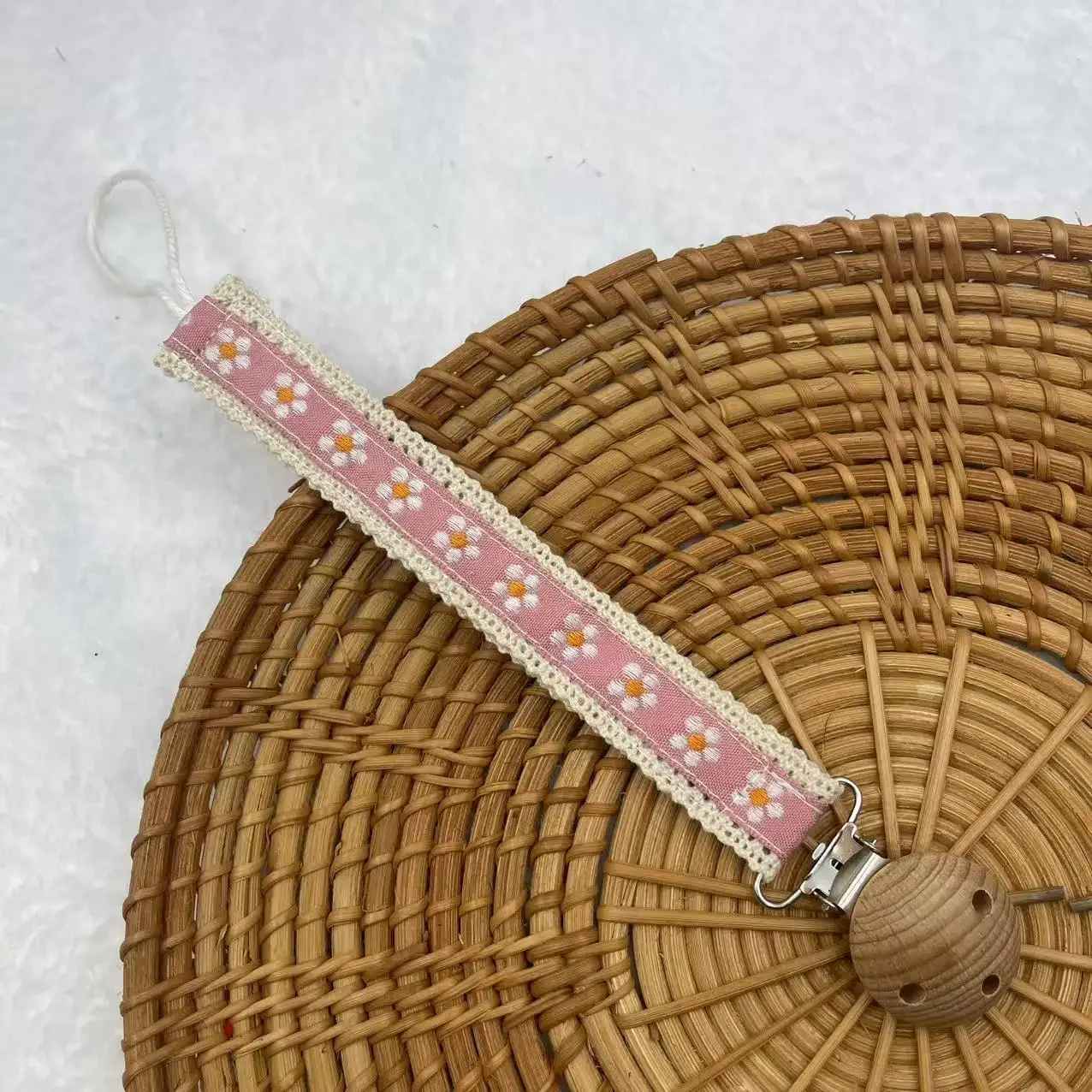 attache suce motifs fleurs blanches et fond rose
