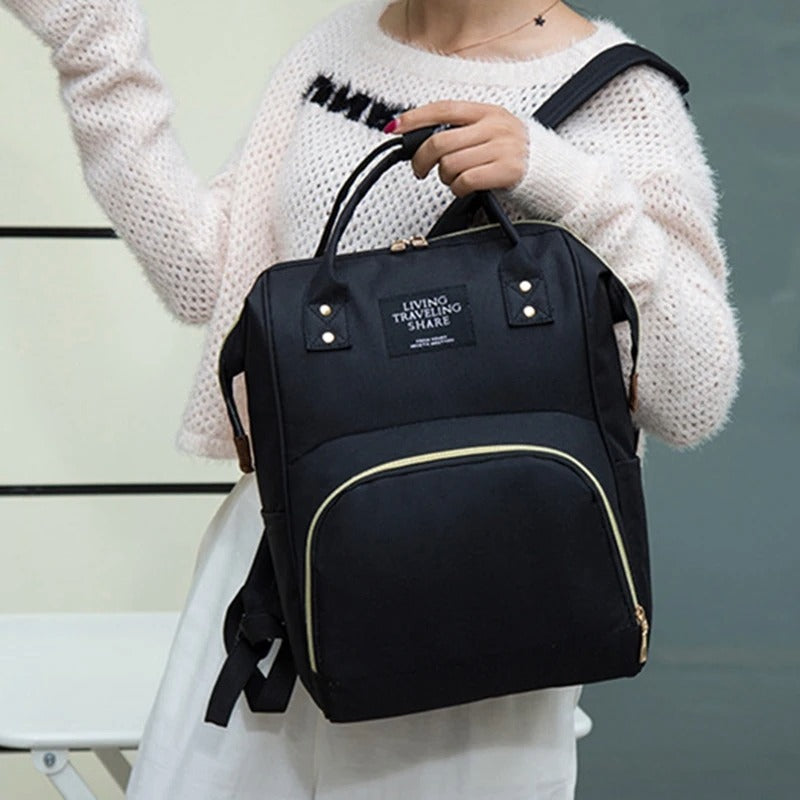 Sac à dos à langer de couleur noir porté en bandoulière ou en sac à main