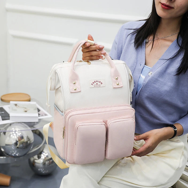 Sac a dos a langer rose et blanc avec pognées robustes et bretelles rembourrées